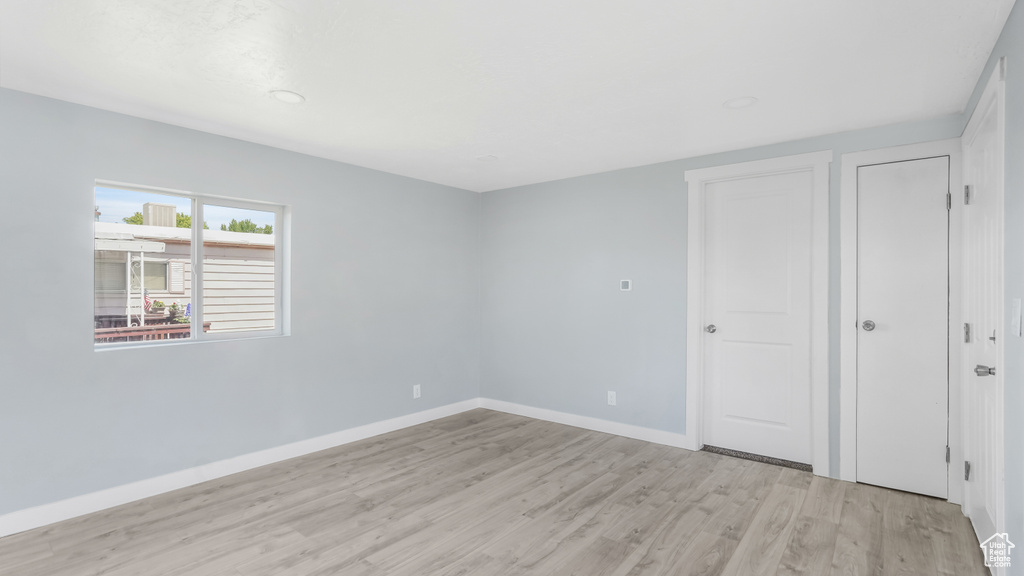 Unfurnished bedroom featuring light wood-style floors and baseboards
