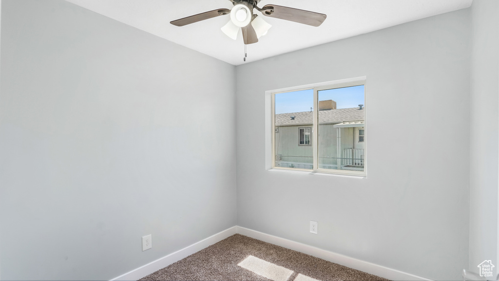 Empty room with baseboards, carpet flooring, and a ceiling fan