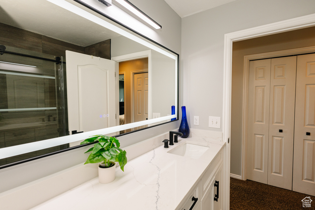 Bathroom featuring vanity, a closet, and an enclosed shower