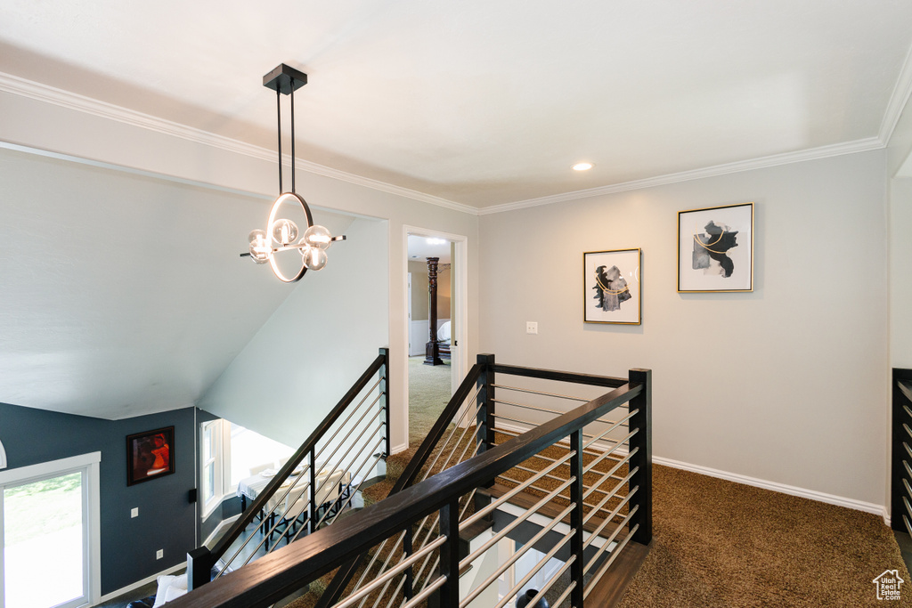 Corridor with an upstairs landing, carpet floors, a chandelier, crown molding, and baseboards