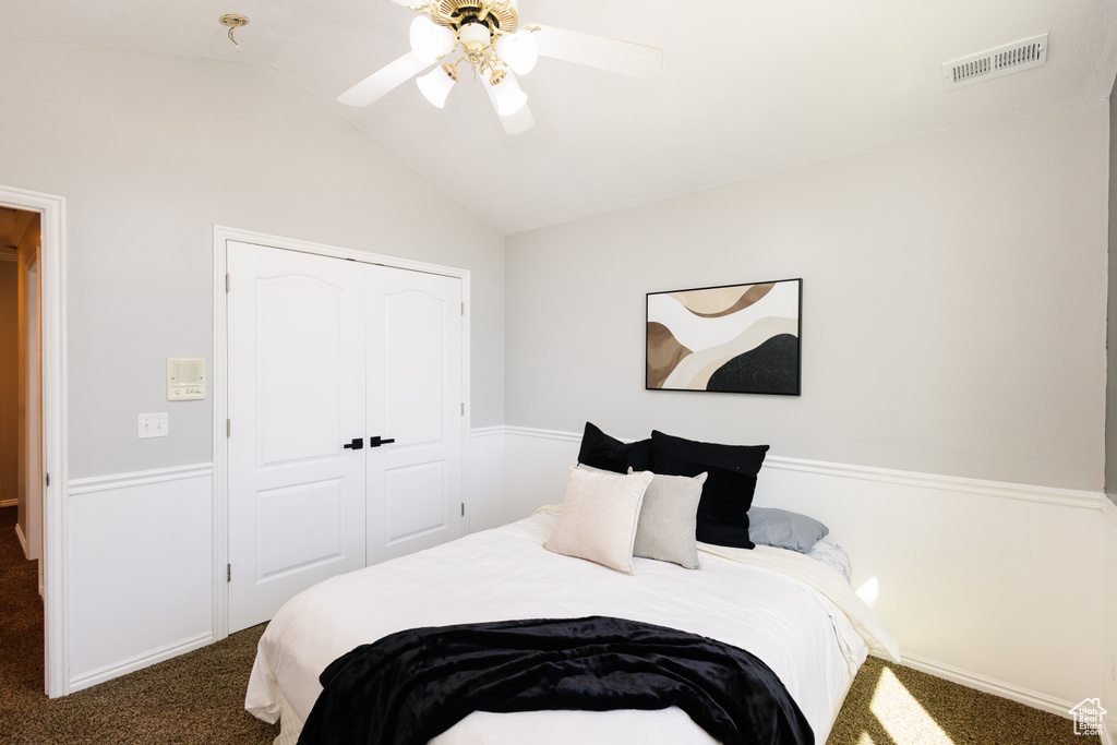 Carpeted bedroom featuring lofted ceiling, a closet, and ceiling fan