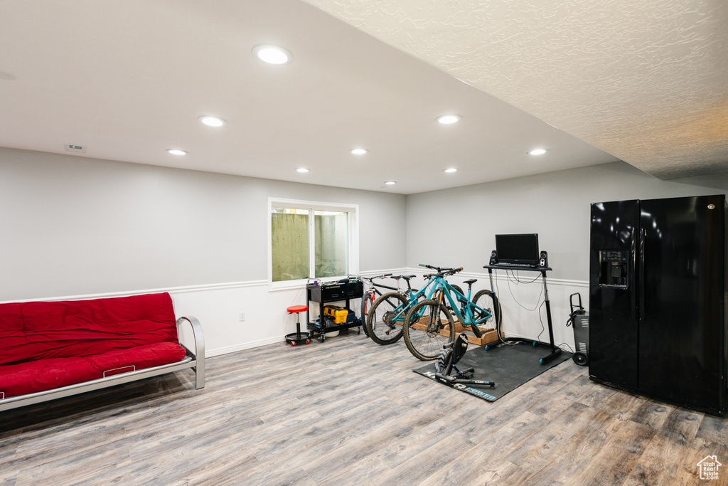 Exercise room with wood finished floors, recessed lighting, and baseboards