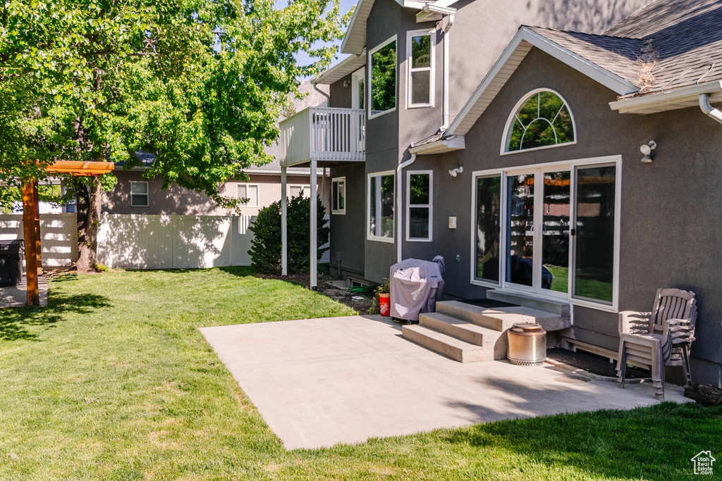 Back of property featuring stucco siding, a balcony, a patio, and entry steps