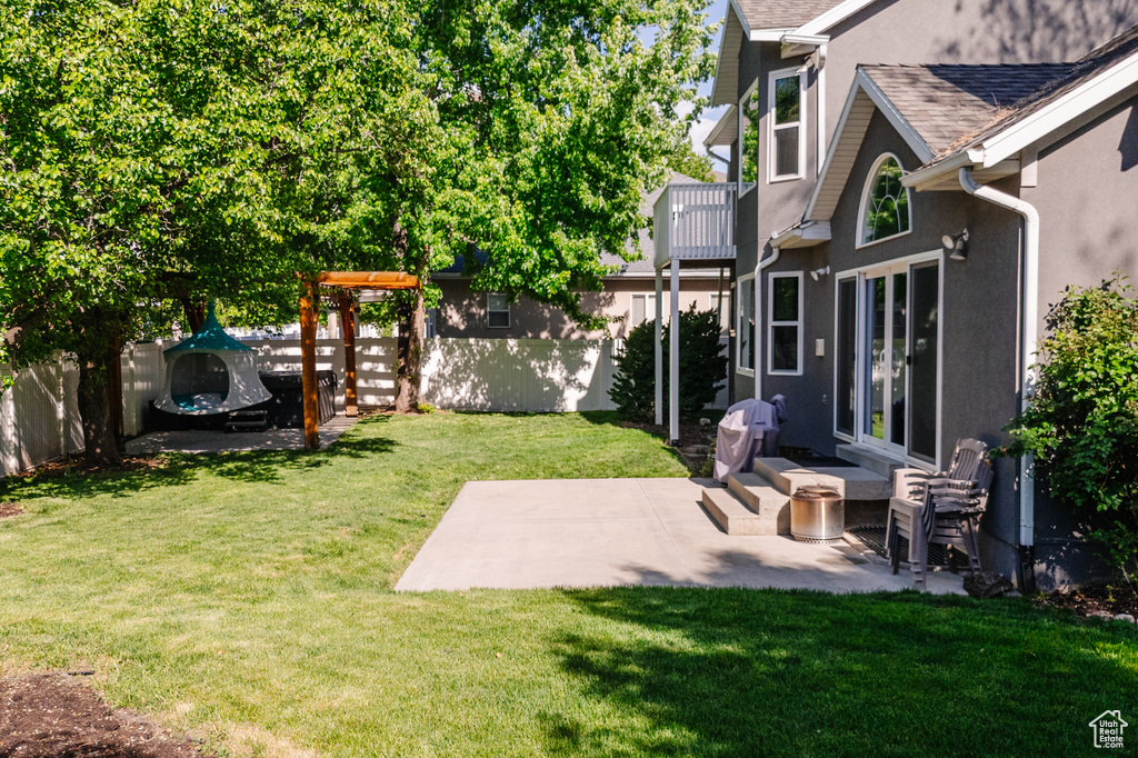 View of yard featuring a patio and a balcony