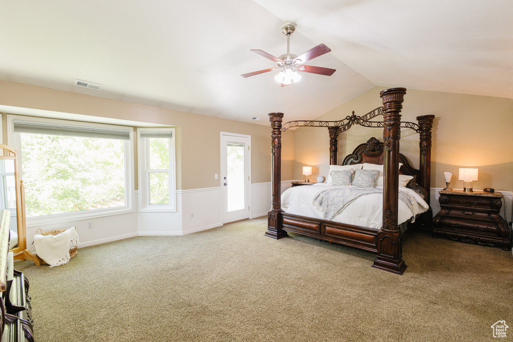 Carpeted bedroom featuring lofted ceiling and a ceiling fan