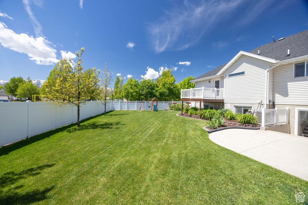 View of yard featuring a patio and a wooden deck
