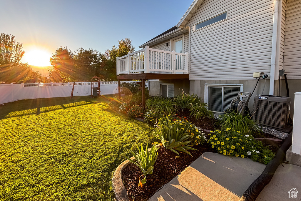 View of yard with central air condition unit and a wooden deck