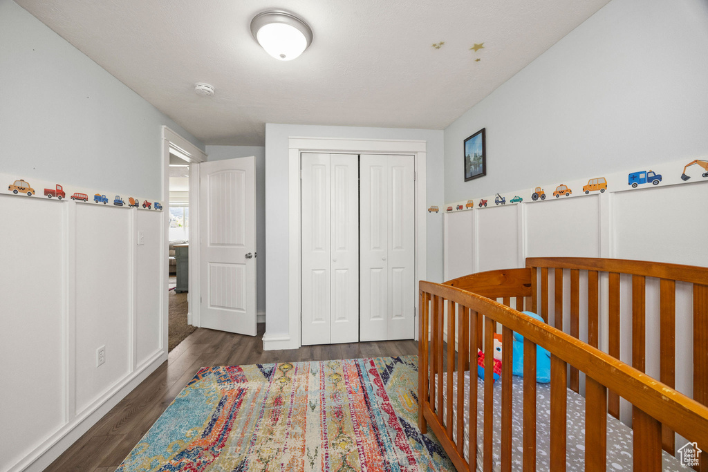 Bedroom with a closet and dark wood-style floors