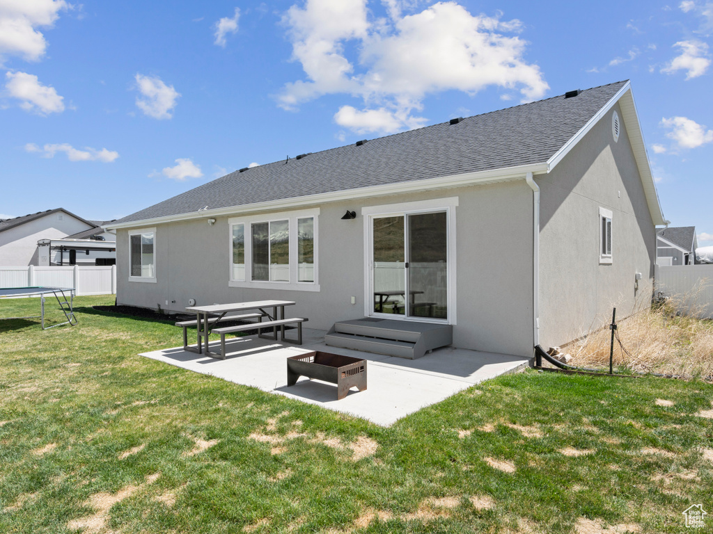 Rear view of property with a patio, stucco siding, a trampoline, and roof with shingles