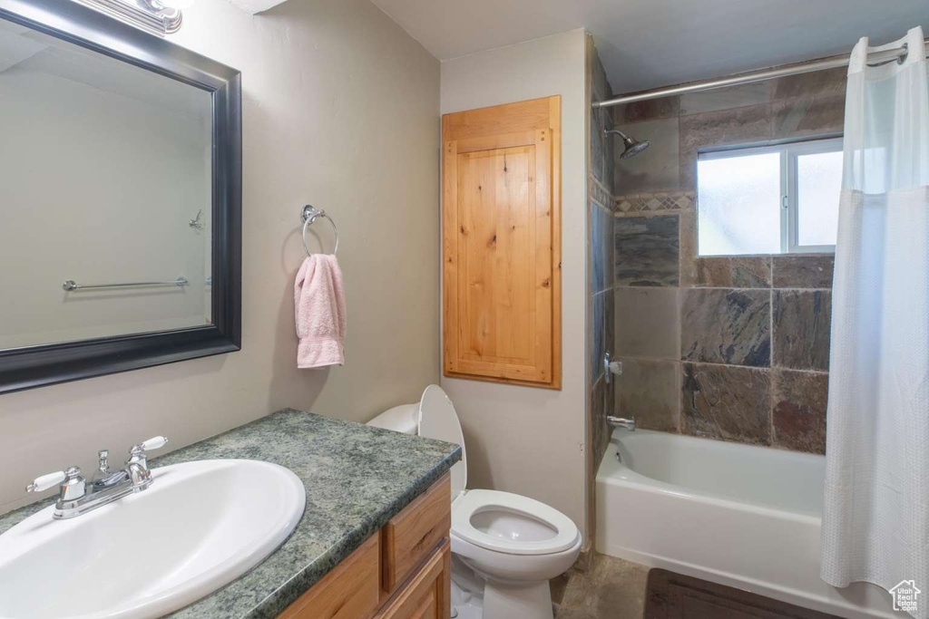 Bathroom featuring toilet, bathing tub / shower combination, and vanity