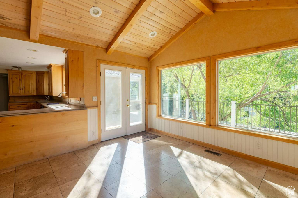Doorway featuring french doors, a sink, light tile patterned floors, and baseboards