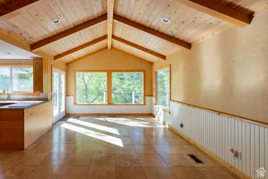 Unfurnished living room with a wainscoted wall, a sink, and wooden ceiling