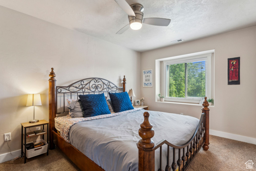 Carpeted bedroom with baseboards and a ceiling fan