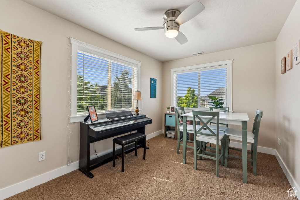 Carpeted dining room featuring ceiling fan, an office area, and baseboards