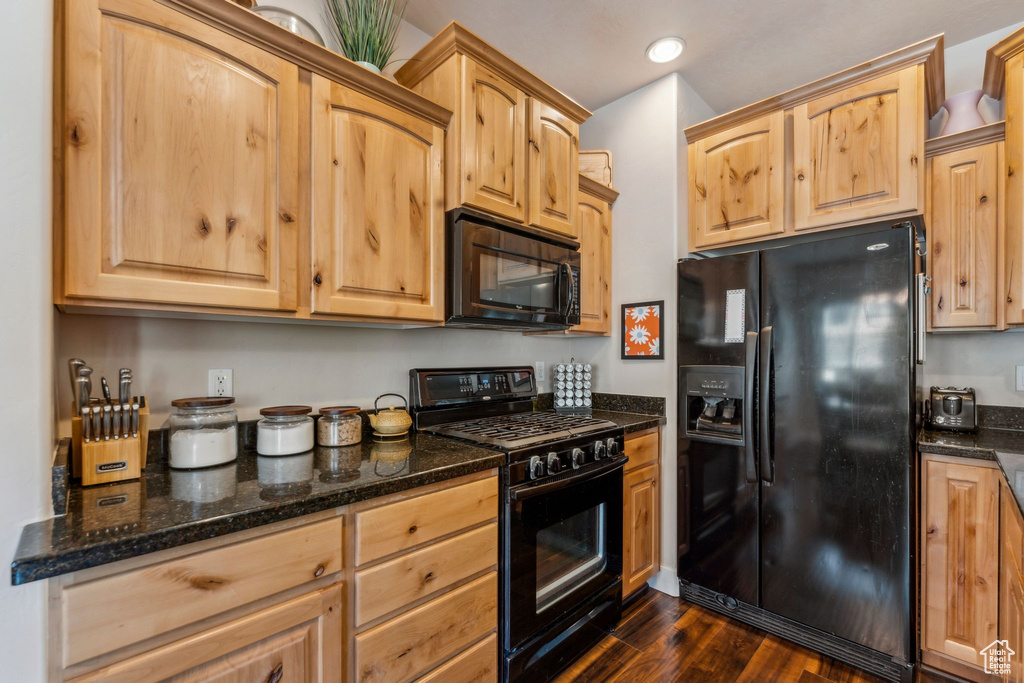 Kitchen with black appliances, dark wood finished floors, dark stone countertops, recessed lighting, and light brown cabinets