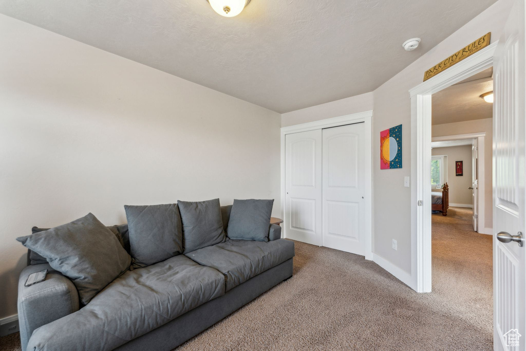 Carpeted living area featuring baseboards