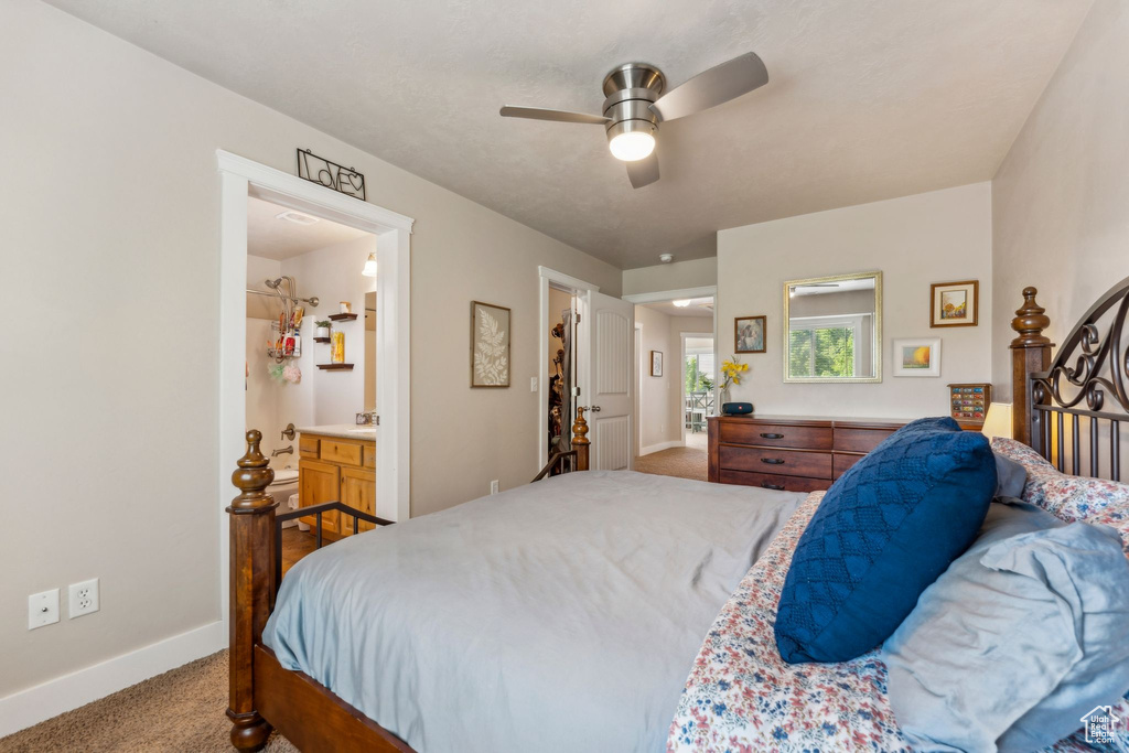 Carpeted bedroom featuring baseboards, ceiling fan, and connected bathroom