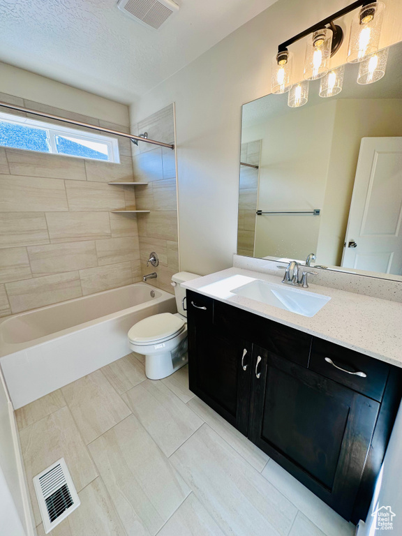 Full bath featuring toilet, vanity, tub / shower combination, and a textured ceiling