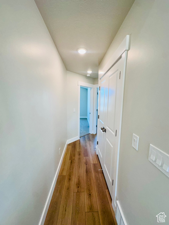 Hallway with baseboards and wood-type flooring