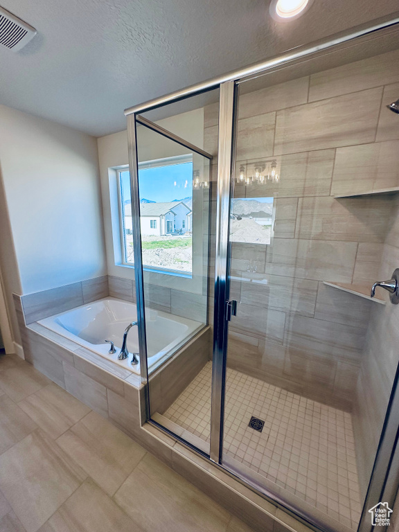 Bathroom with a bath, a stall shower, and tile patterned flooring