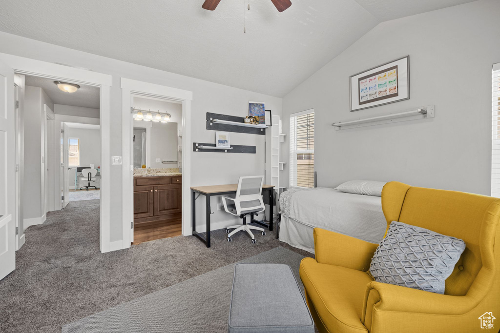Carpeted bedroom featuring lofted ceiling, ensuite bathroom, baseboards, and a ceiling fan