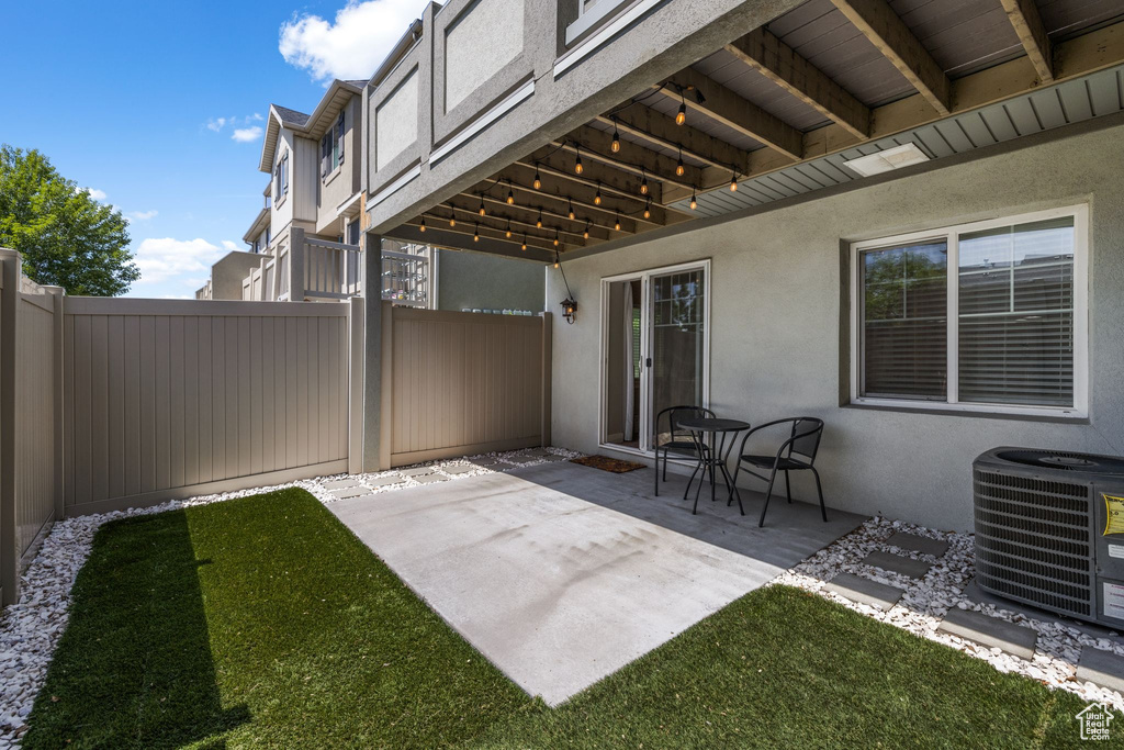 View of patio with central AC unit and a fenced backyard