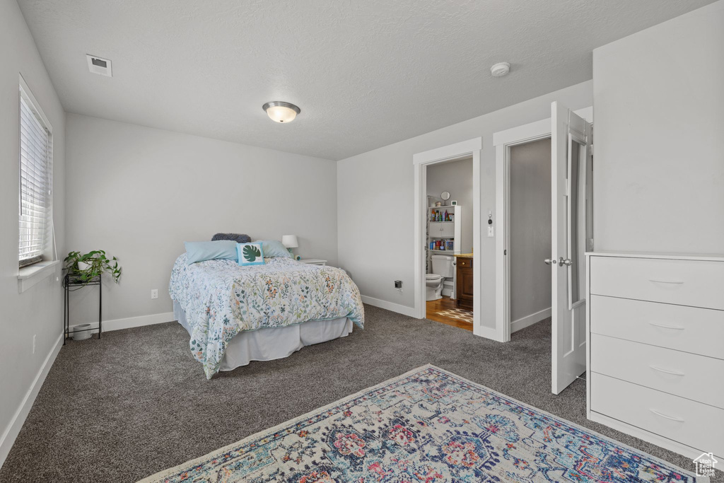 Bedroom featuring carpet flooring, baseboards, and ensuite bathroom