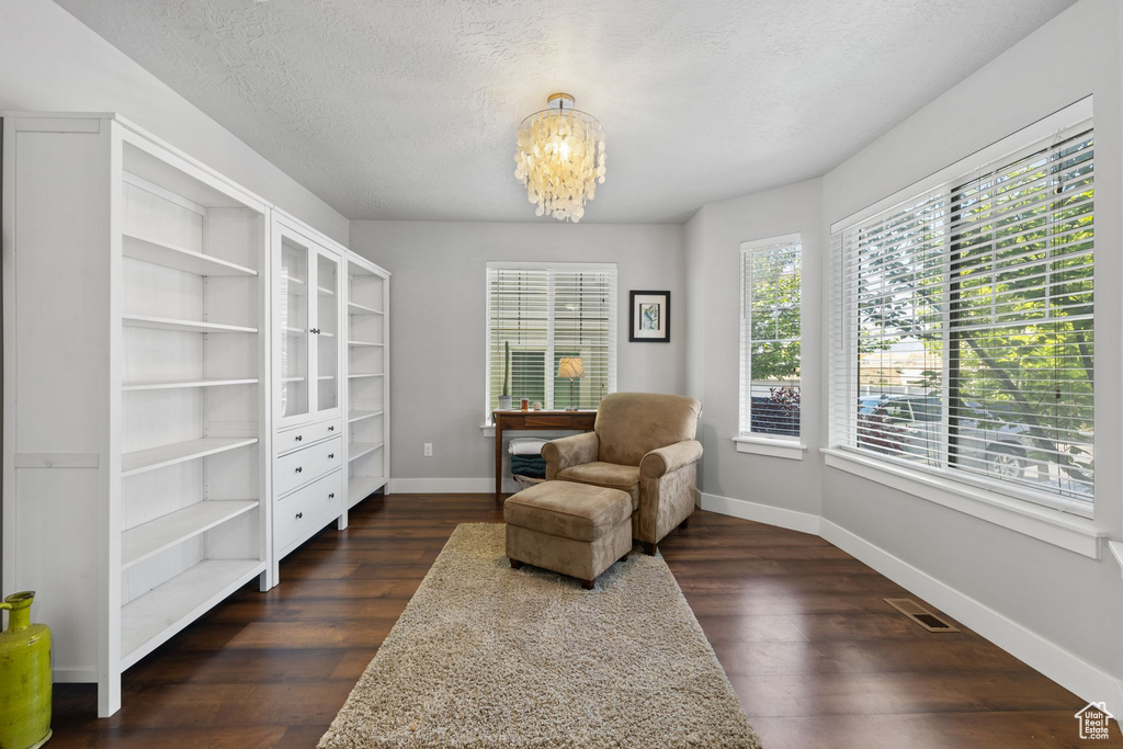 Sitting room with a chandelier, a desk, dark wood-style flooring, baseboards, and a textured ceiling
