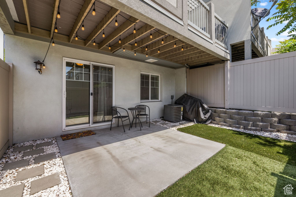 View of patio with fence and central air condition unit