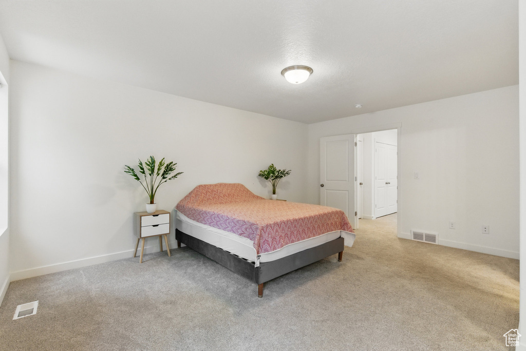 Bedroom featuring light colored carpet and baseboards