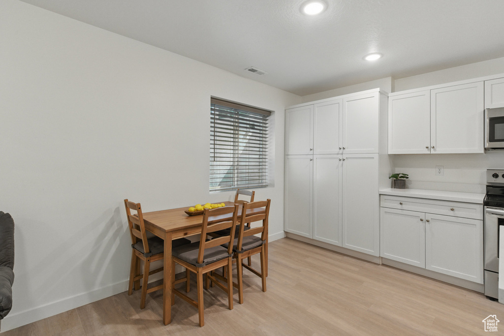 Dining space featuring light wood-style flooring, baseboards, and recessed lighting
