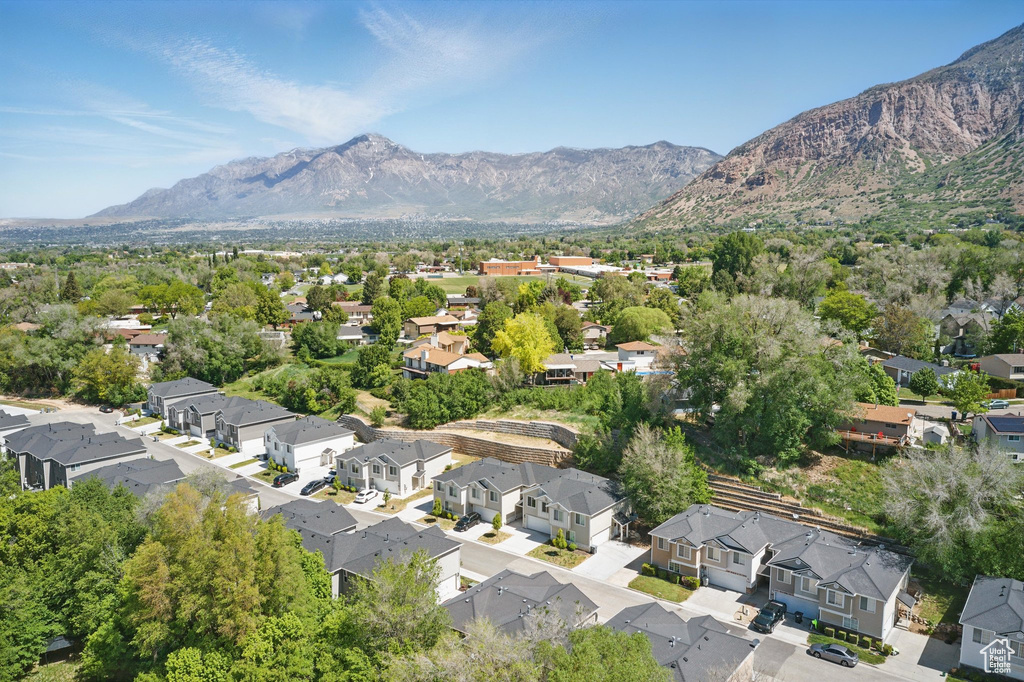 Aerial view of property and surrounding area featuring a mountainous background and nearby suburban area
