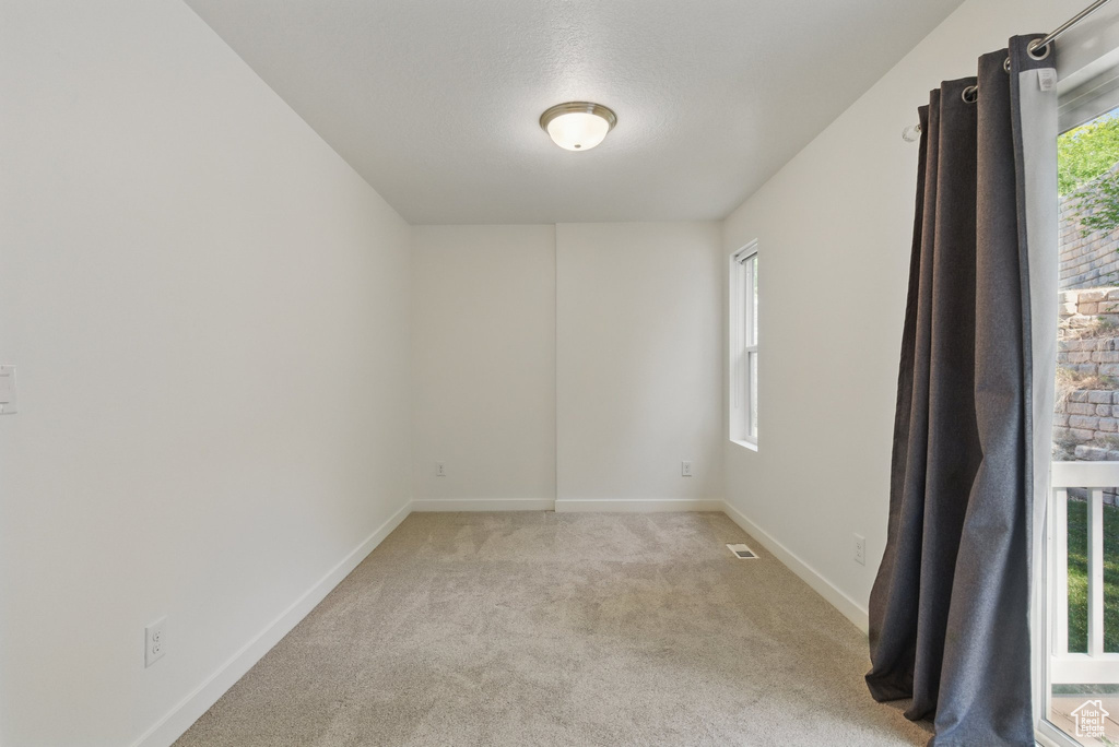 Unfurnished room featuring light colored carpet and baseboards