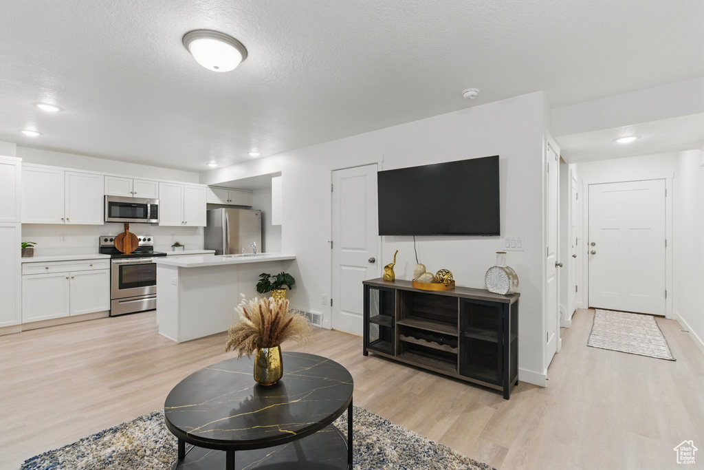 Living room featuring light wood-type flooring, recessed lighting, and baseboards