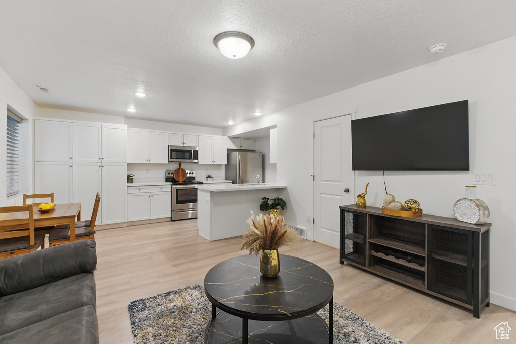 Living room with light wood-style floors and recessed lighting