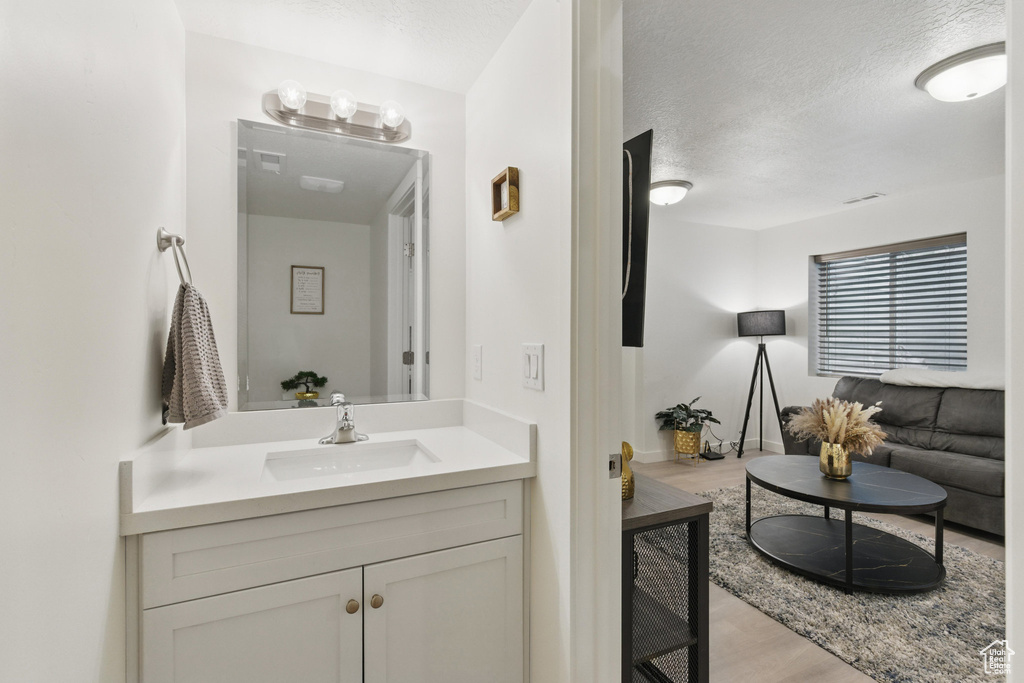 Bathroom featuring wood finished floors, a textured ceiling, and vanity
