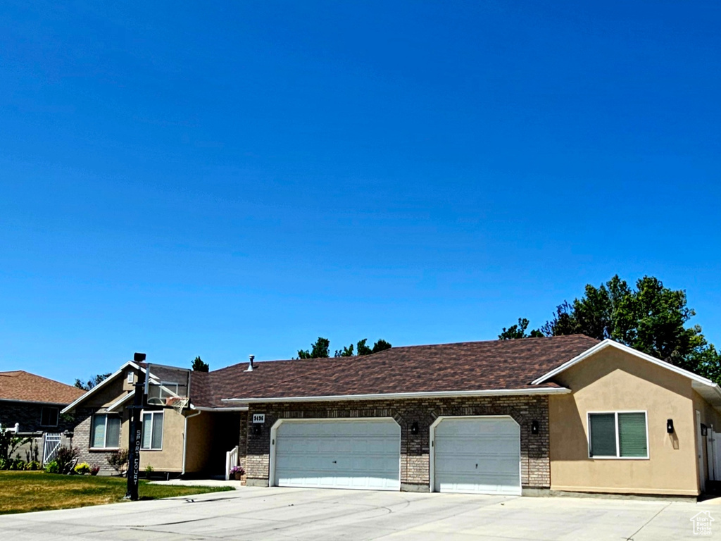 Ranch-style home with a garage, concrete driveway, and brick siding