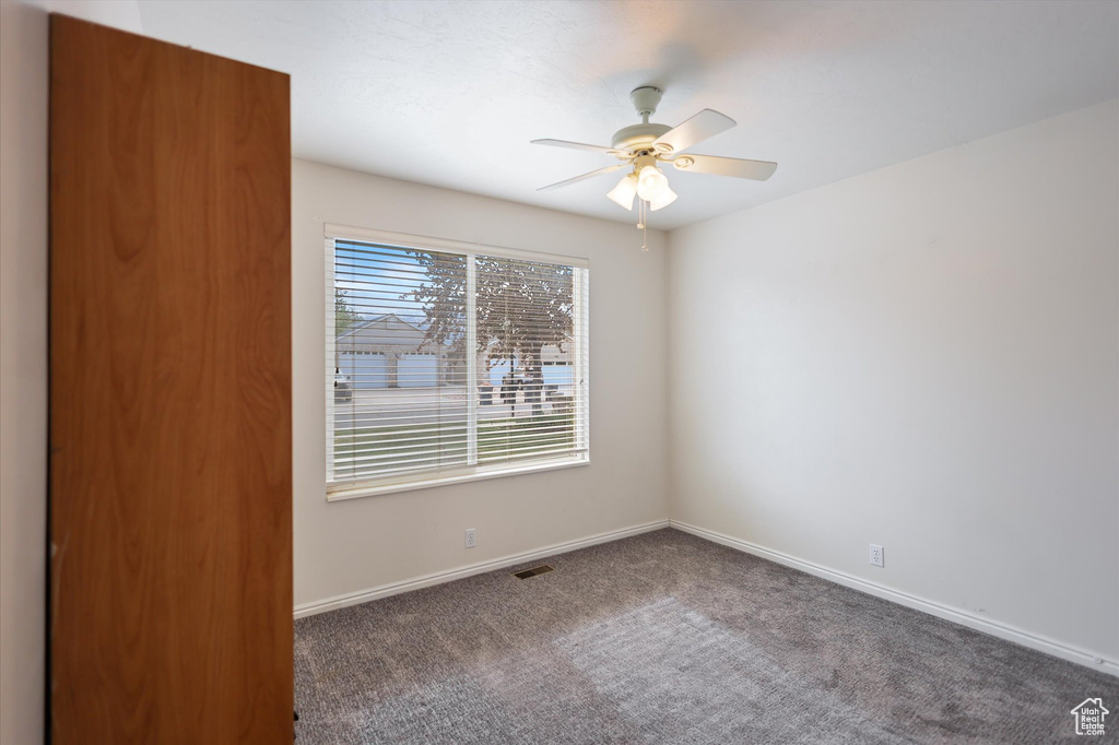 Empty room with carpet floors, baseboards, and ceiling fan