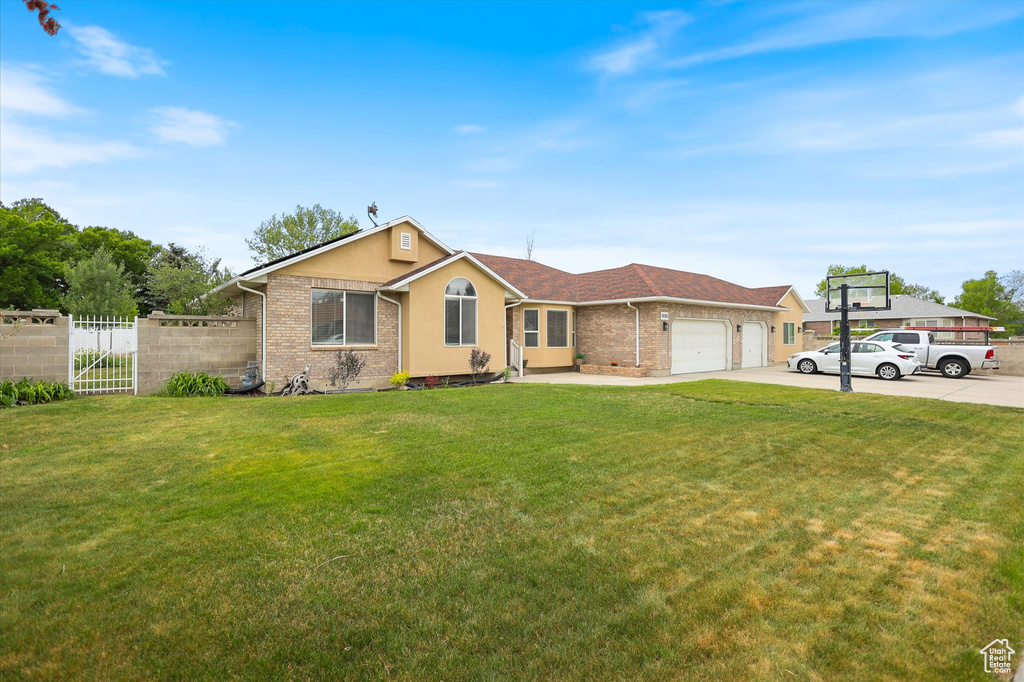 Ranch-style house featuring an attached garage, brick siding, driveway, and stucco siding