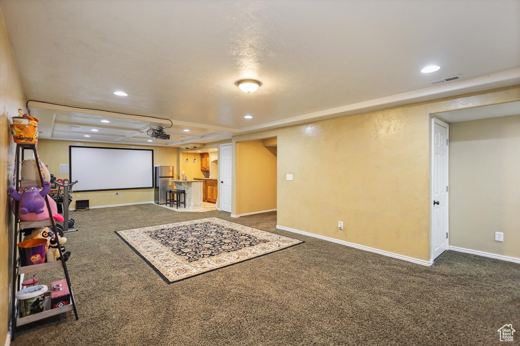 Living area with carpet floors, recessed lighting, a tray ceiling, and baseboards