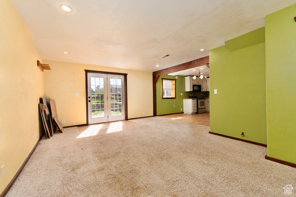 Unfurnished living room with carpet, baseboards, and recessed lighting