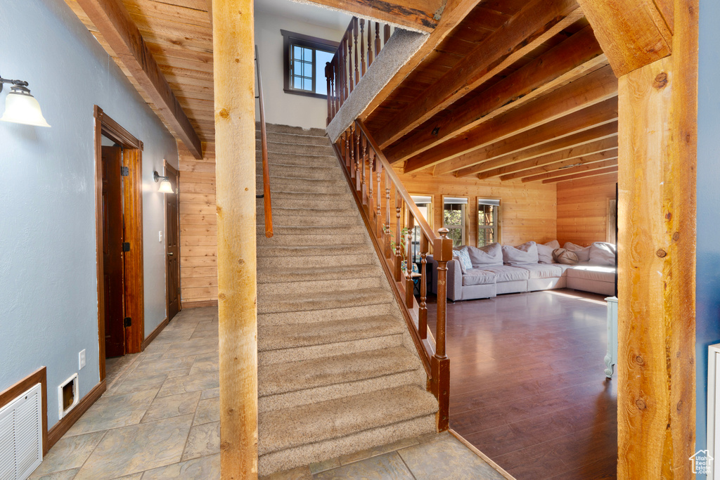 Stairs with wooden walls and healthy amount of natural light