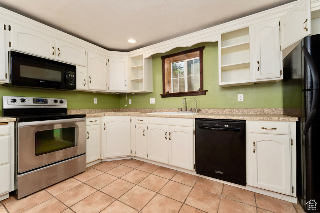 Kitchen featuring black appliances, open shelves, a sink, light tile patterned flooring, and light countertops