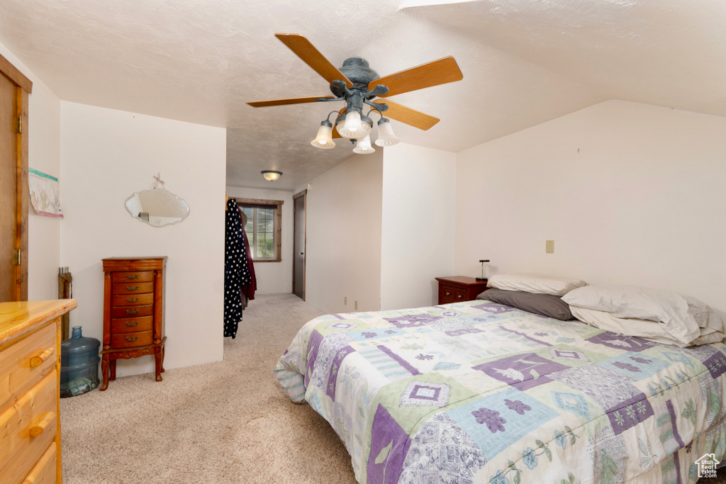 Bedroom with light carpet, a ceiling fan, and lofted ceiling