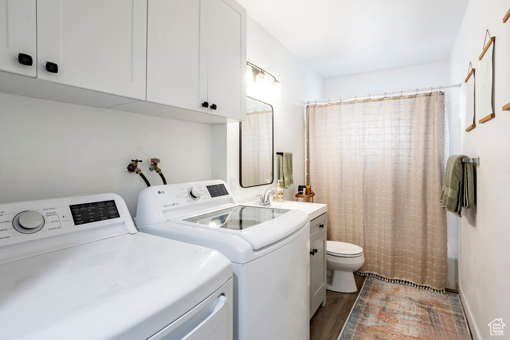 Laundry area with washer and dryer and wood finished floors