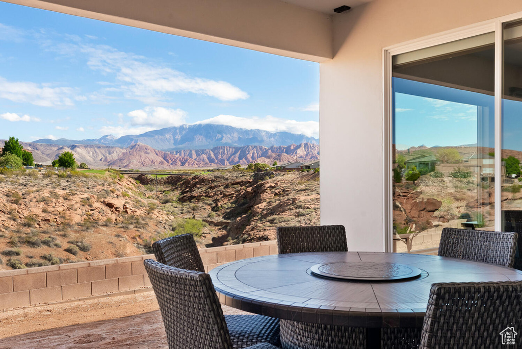 Wooden terrace featuring a mountain view and outdoor dining space