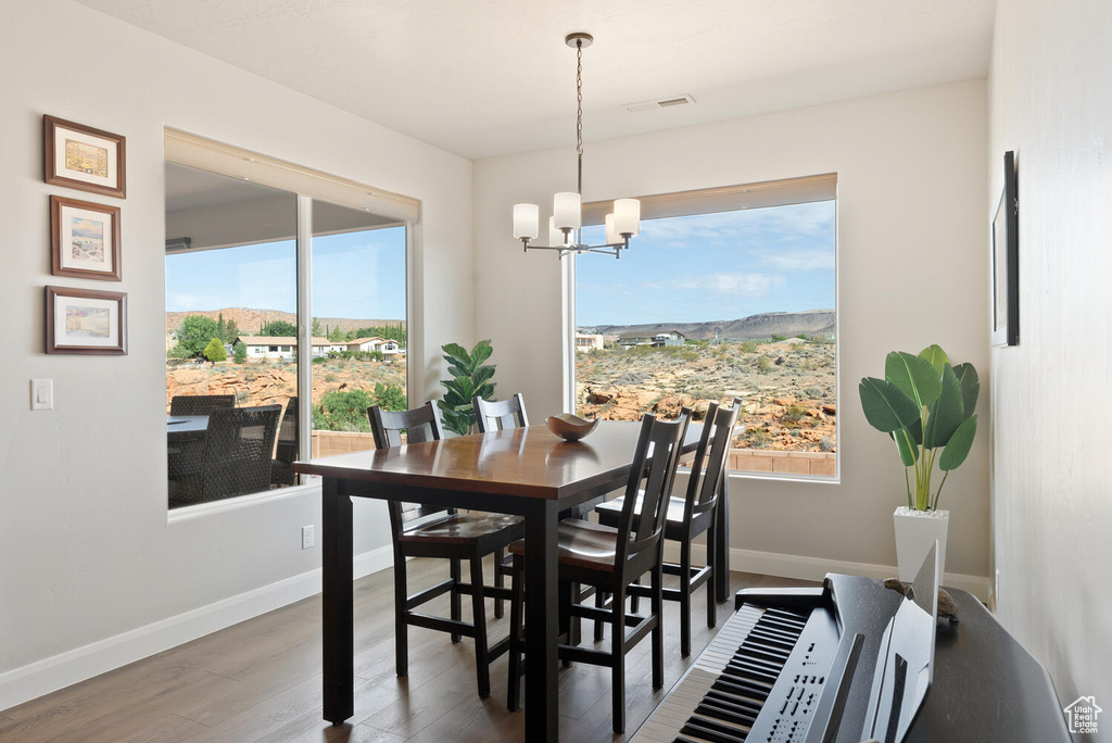 Dining area featuring a chandelier, wood finished floors, baseboards, and a mountain view