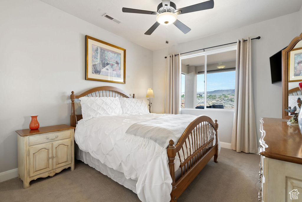 Bedroom featuring light carpet, baseboards, and ceiling fan