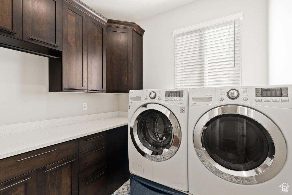 Laundry area with cabinet space and washer and clothes dryer