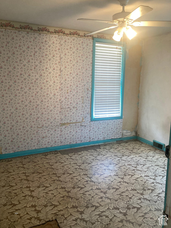 Unfurnished room with a ceiling fan and carpet floors